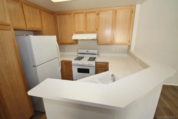 a kitchen with a white stove top oven and refrigerator