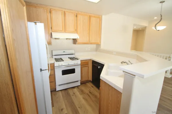 a kitchen with a white stove top oven and sink