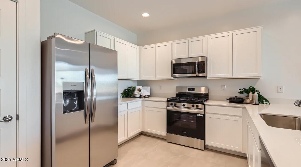 23407 West Bloch Road Buckeye, AZ 85326 - Photo 3 of 22 a kitchen with a refrigerator stove and microwave