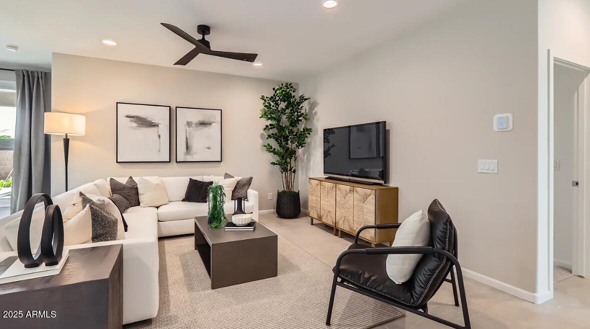 23407 West Bloch Road Buckeye, AZ 85326 - Photo 9 of 22 a living room with furniture a flat screen tv and a potted plant