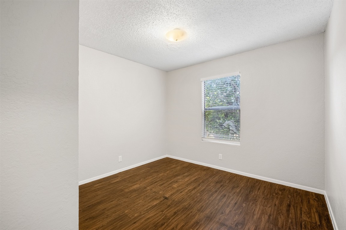12901 Chromite Street, Unit B Austin, TX 78727 - Photo 11 of 21 Spare room with dark wood-type flooring and a textured ceiling