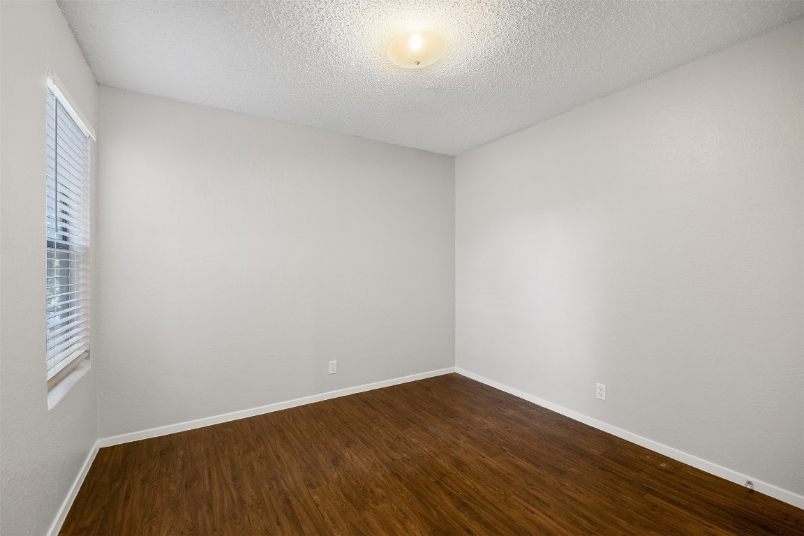 12901 Chromite Street, Unit B Austin, TX 78727 - Photo 9 of 21 Spare room with dark wood-type flooring and a textured ceiling