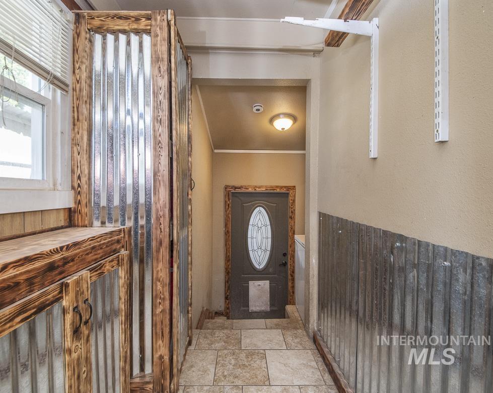486 West Main Street South Vale, OR 97918 - Photo 16 of 37 Entryway featuring wood-finish cabinetry with corrugated metal paneling and a coordinating metal wainscoting