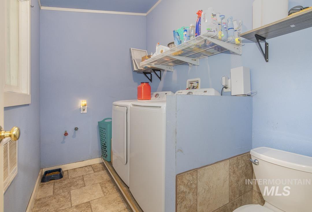 486 West Main Street South Vale, OR 97918 - Photo 17 of 37 Utility room featuring tiled flooring, blue wall paint, and a built-in toilet