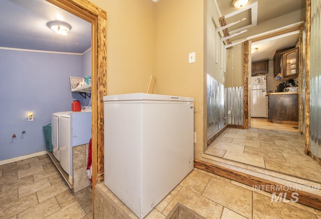 486 West Main Street South Vale, OR 97918 - Photo 18 of 37 Utility area featuring tile flooring, wood-framed doorways, and a laundry alcove with built-in shelving