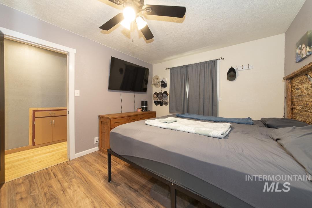 486 West Main Street South Vale, OR 97918 - Photo 19 of 37 Bedroom featuring wood-finish flooring, a ceiling fan with integrated lighting, and a window with curtain rod