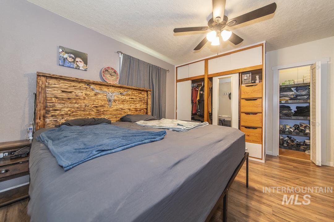 486 West Main Street South Vale, OR 97918 - Photo 20 of 37 Bedroom featuring wood-finish flooring, a ceiling fan with integrated lighting, and a built-in wardrobe with sliding doors and integrated drawers