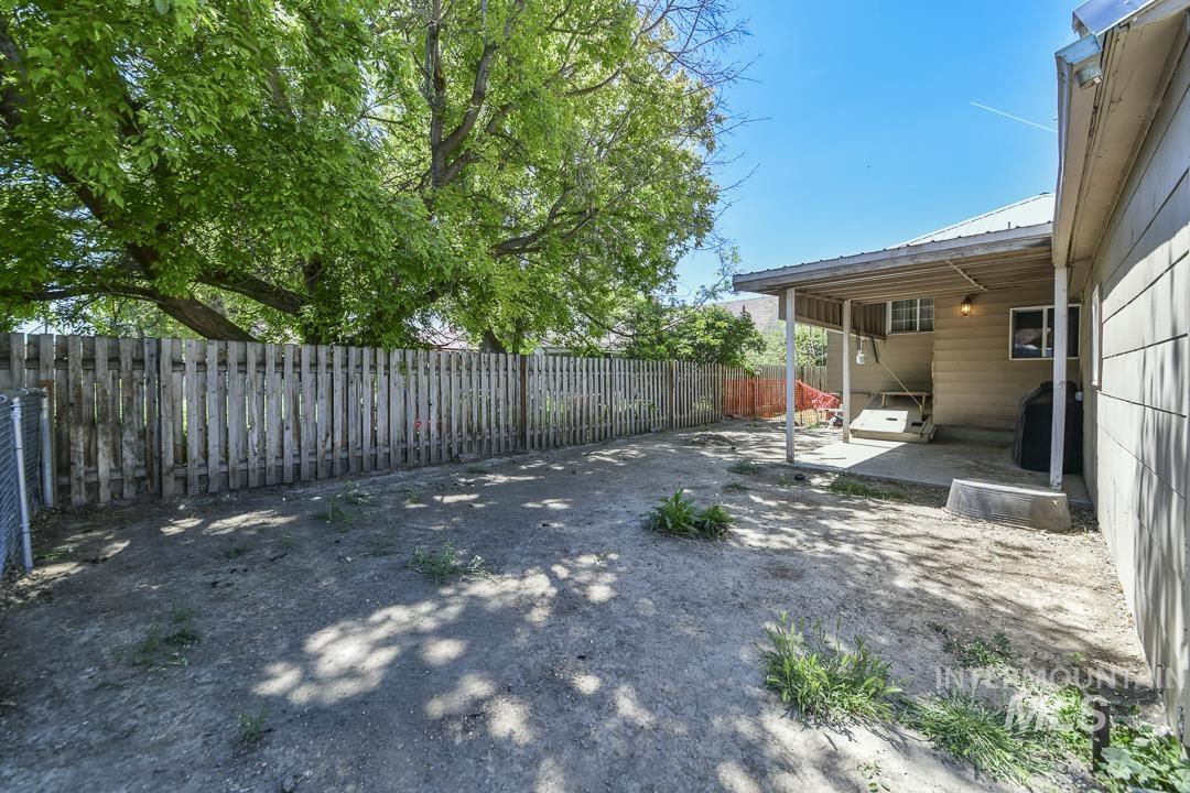 486 West Main Street South Vale, OR 97918 - Photo 32 of 37 Expansive backyard featuring a covered patio, perimeter fencing, and mature trees providing natural shade