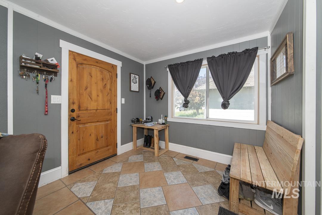486 West Main Street South Vale, OR 97918 - Photo 5 of 37 Entryway featuring a natural wood-finish door, light gray walls with white trim, and a patterned tile floor