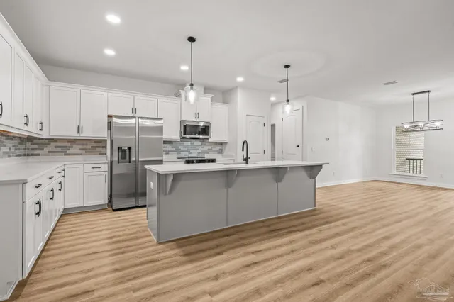 a kitchen with a sink a counter top space stainless steel appliances and cabinets
