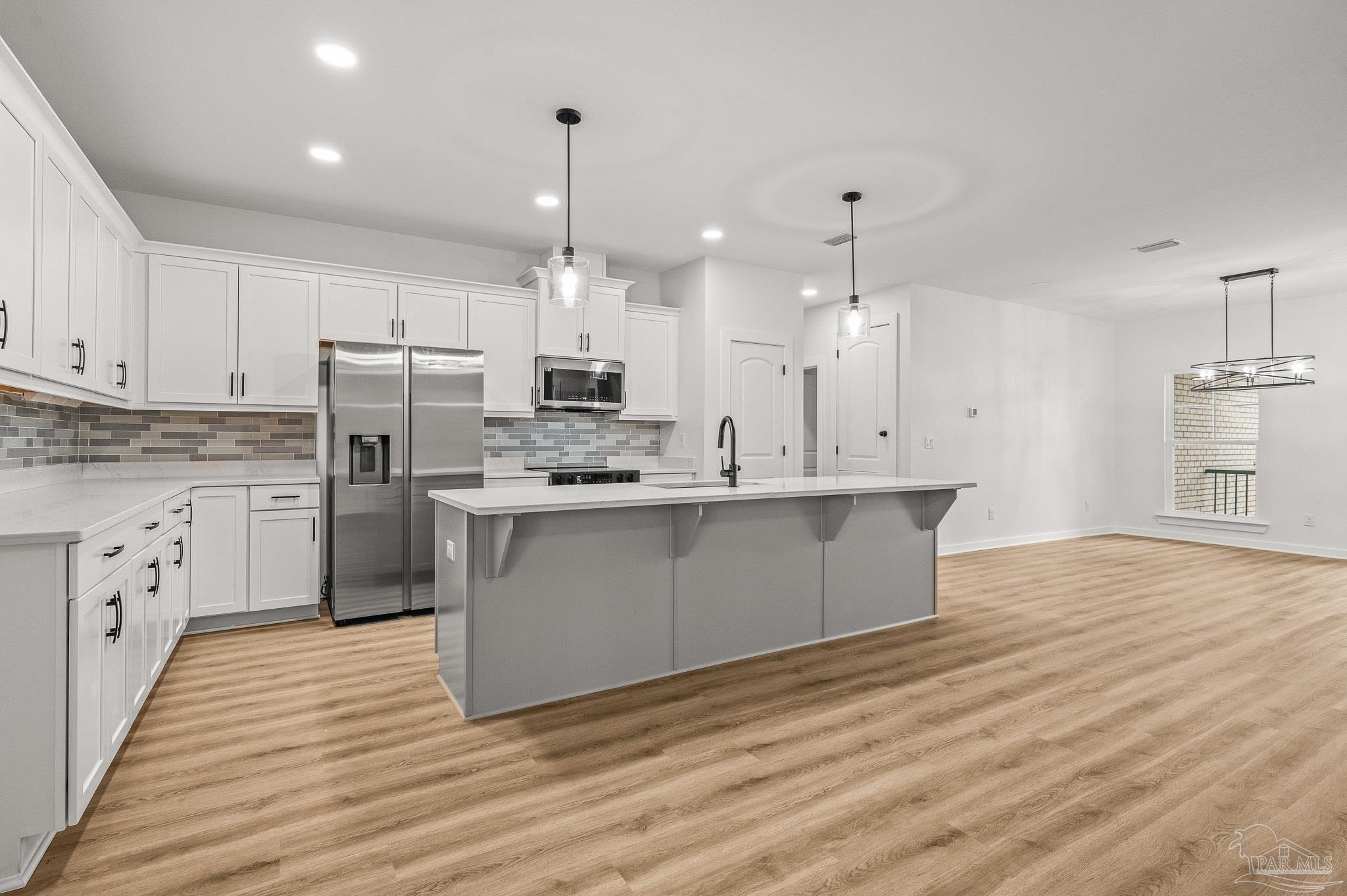 1192 Adrian Way Milton, FL 32583 - Photo 11 of 37 a large kitchen with cabinets wooden floor and a stainless steel appliances