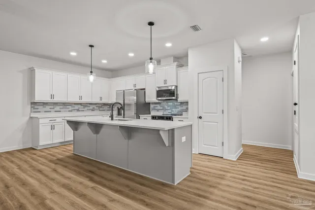 a kitchen with stainless steel appliances granite countertop a sink a stove and a refrigerator