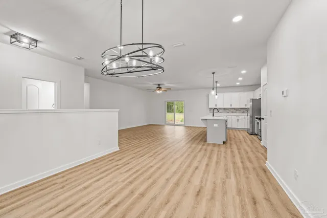 a view of an empty room and window and wooden floor