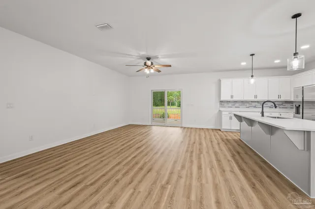 a bedroom with a large bed and a flat tv screen on dresser