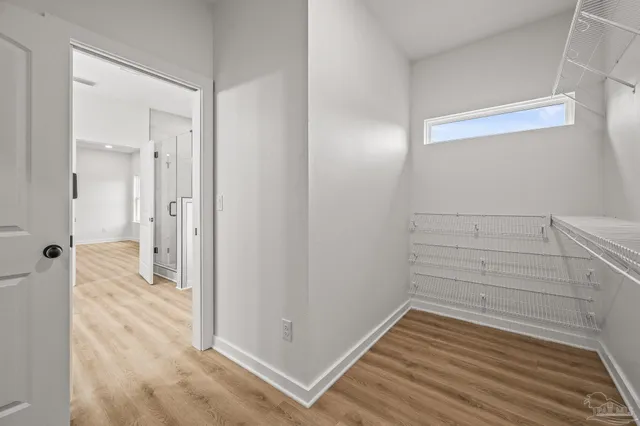 a view of a hallway with wooden floor and closet