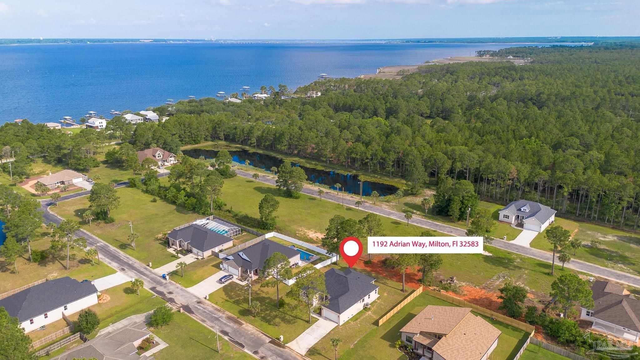 1192 Adrian Way Milton, FL 32583 - Photo 35 of 37 a view of a lake with a yard