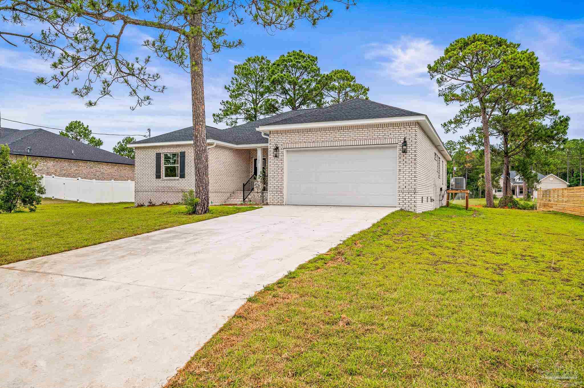 1192 Adrian Way Milton, FL 32583 - Photo 37 of 37 a front view of a house with a yard and garage