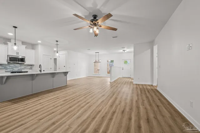 a large kitchen with cabinets wooden floor and a stainless steel appliances