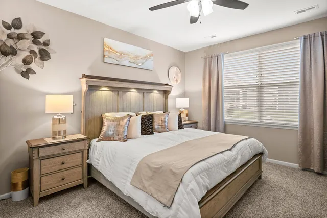 a bedroom with a large bed and a flat tv screen on dresser