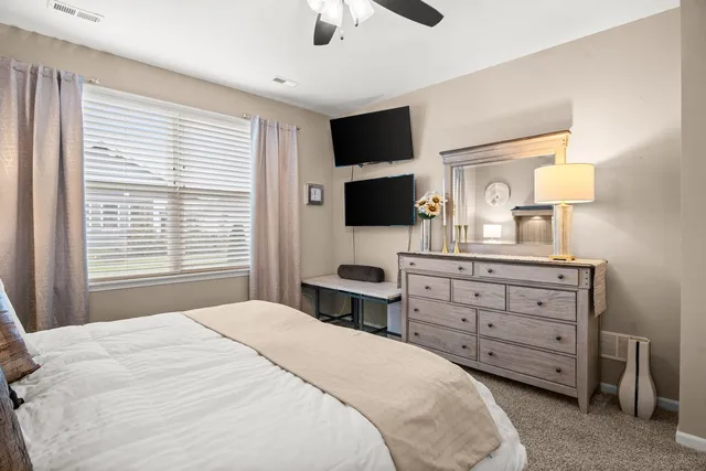 a bedroom with a large bed and a chandelier