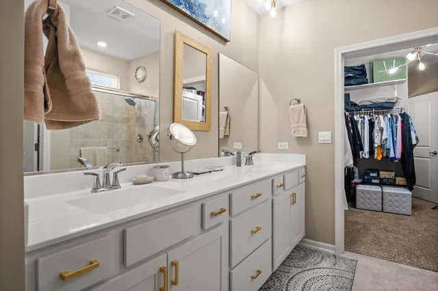 a bathroom with a double vanity sink mirror and shower