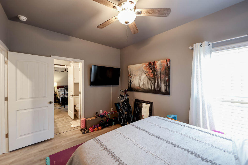 7101 22nd Place Lubbock, TX 79407 - Photo 16 of 24 a bedroom with a bed and a chandelier
