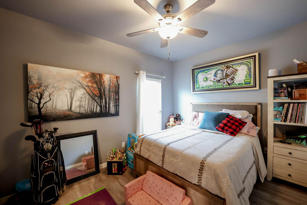 7101 22nd Place Lubbock, TX 79407 - Photo 17 of 24 a bedroom with a bed and a chandelier