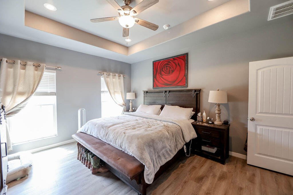 7101 22nd Place Lubbock, TX 79407 - Photo 10 of 24 a bedroom with a bed and a chandelier