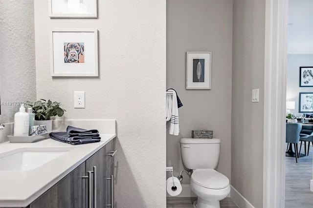 a bathroom with a double vanity sink a toilet and shower