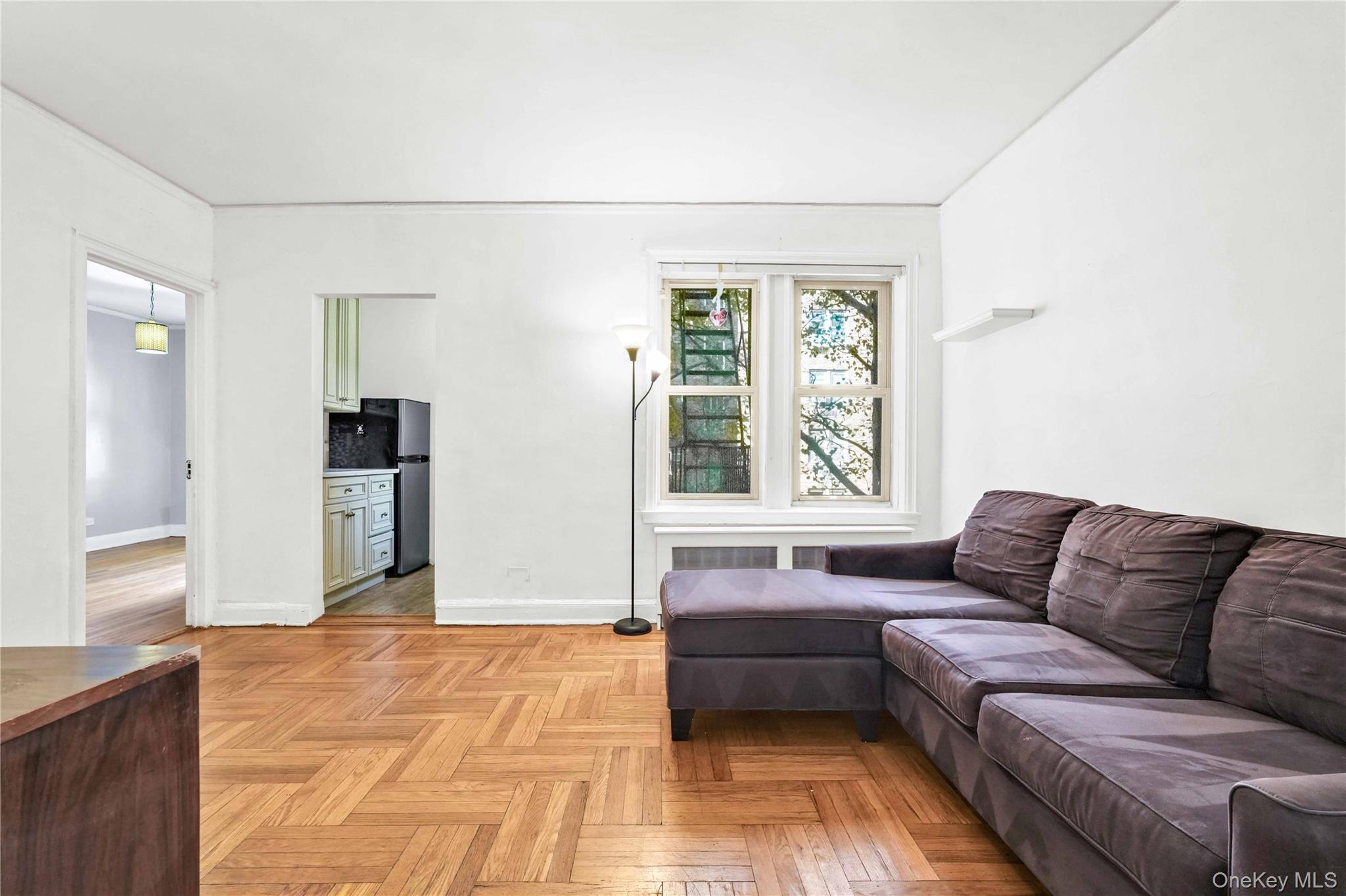 48-50 44th Street, Unit 4E Queens, NY 11377 - Photo 4 of 13 a living room with a couch and a large window
