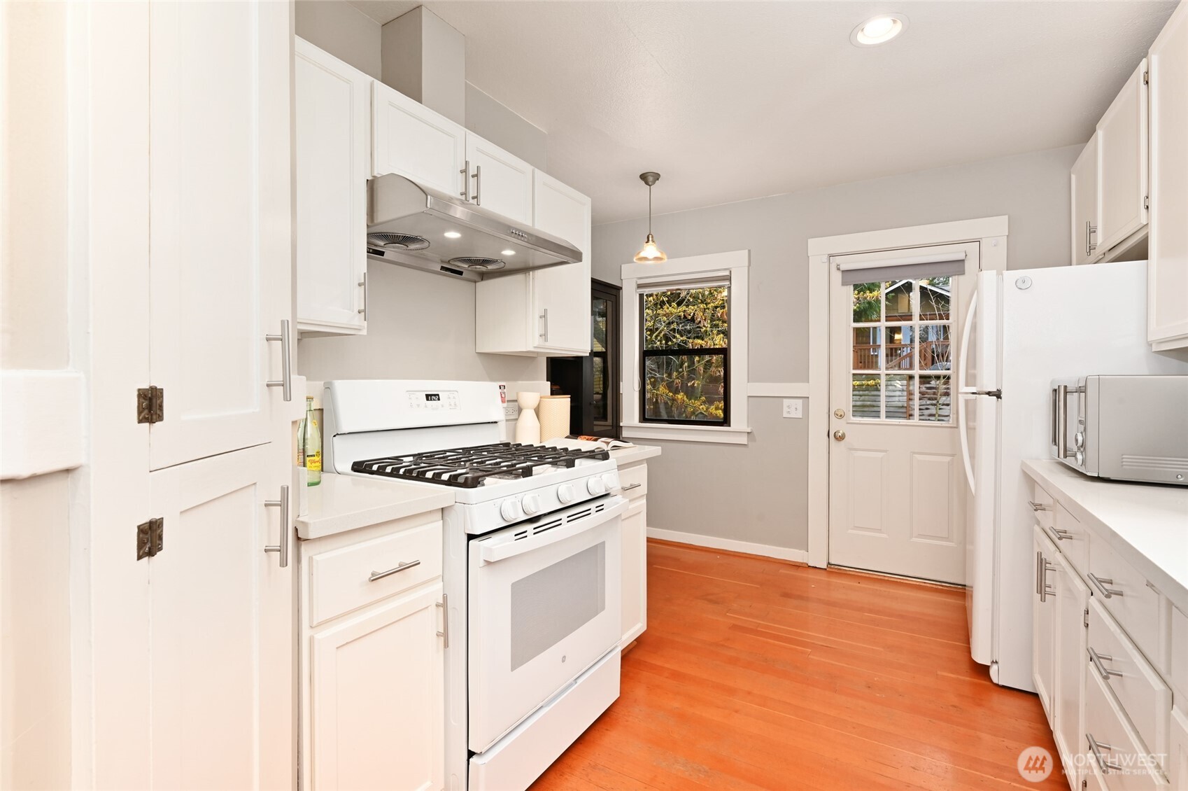 6056 25th Avenue Northeast Seattle, WA 98115 - Photo 10 of 34 a white kitchen with a stove top oven