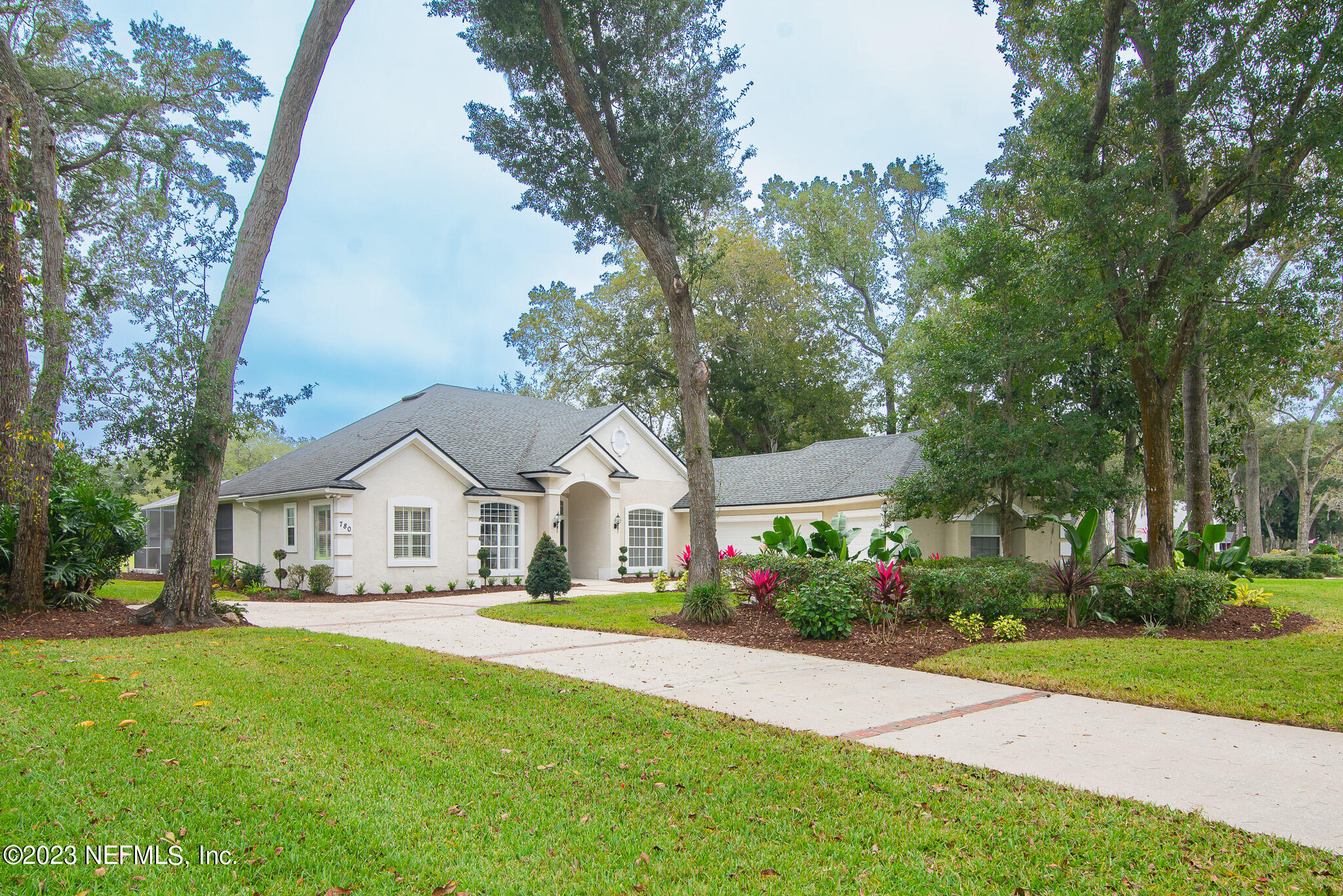 780 Queens Harbor Boulevard Jacksonville, FL 32225 - Photo 3 of 42 a front view of a house with a garden and trees