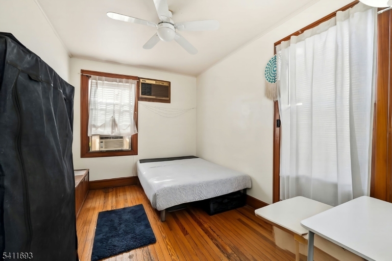 419 Hamilton Street Harrison, NJ 07029 - Photo 14 of 42 a bedroom with a bed and a dresser next to a window