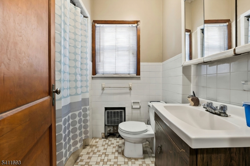 419 Hamilton Street Harrison, NJ 07029 - Photo 24 of 42 a bathroom with a sink a toilet and a mirror