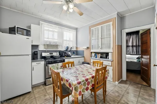 a kitchen with a refrigerator a stove a sink a dining table and chairs