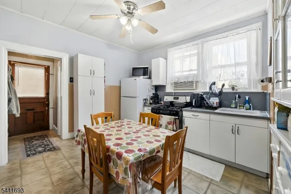 a kitchen with stainless steel appliances kitchen island granite countertop a refrigerator a stove a sink dishwasher a dining table and chairs with wooden floor