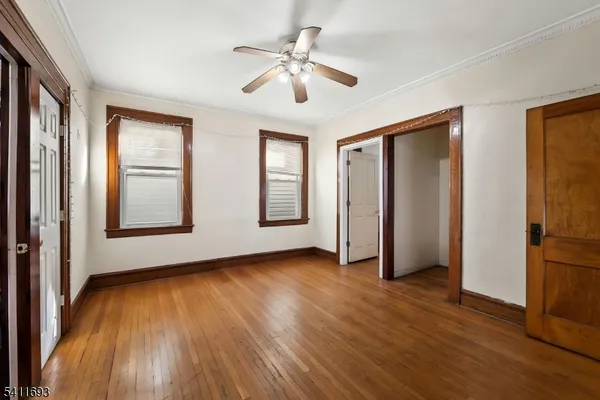 a view of an empty room with a window and wooden floor