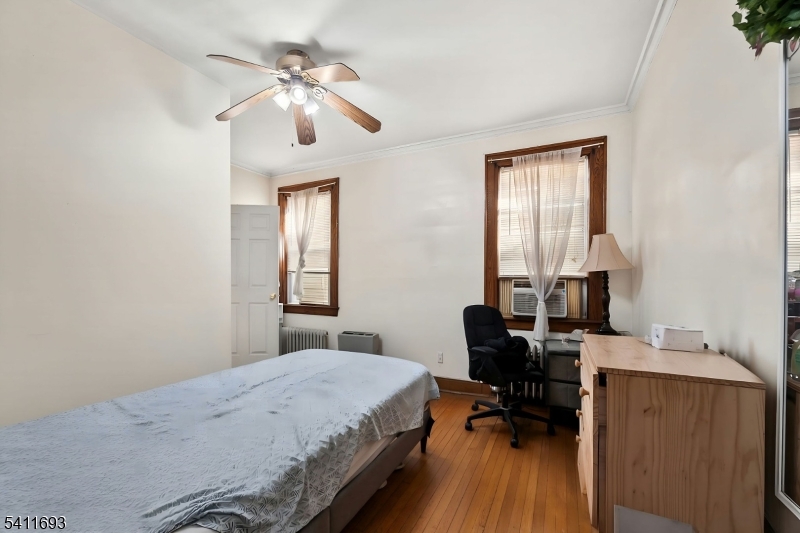 419 Hamilton Street Harrison, NJ 07029 - Photo 10 of 42 a bedroom with a bed and a chandelier