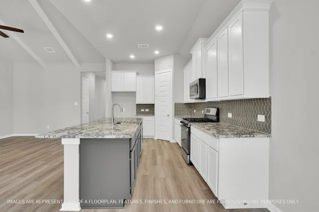 a kitchen with stainless steel appliances granite countertop a sink stove and cabinets