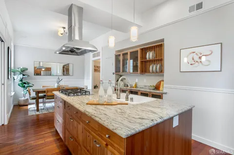 a kitchen with stainless steel appliances granite countertop a sink stove and wooden floor