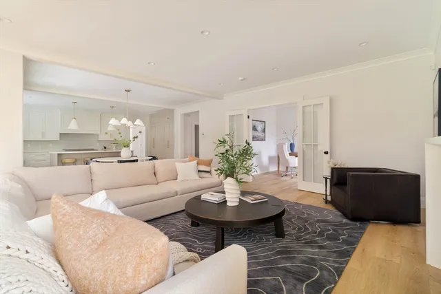 a living room with furniture and view of kitchen