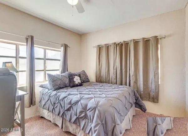 a large bed sitting in a bedroom next to a window