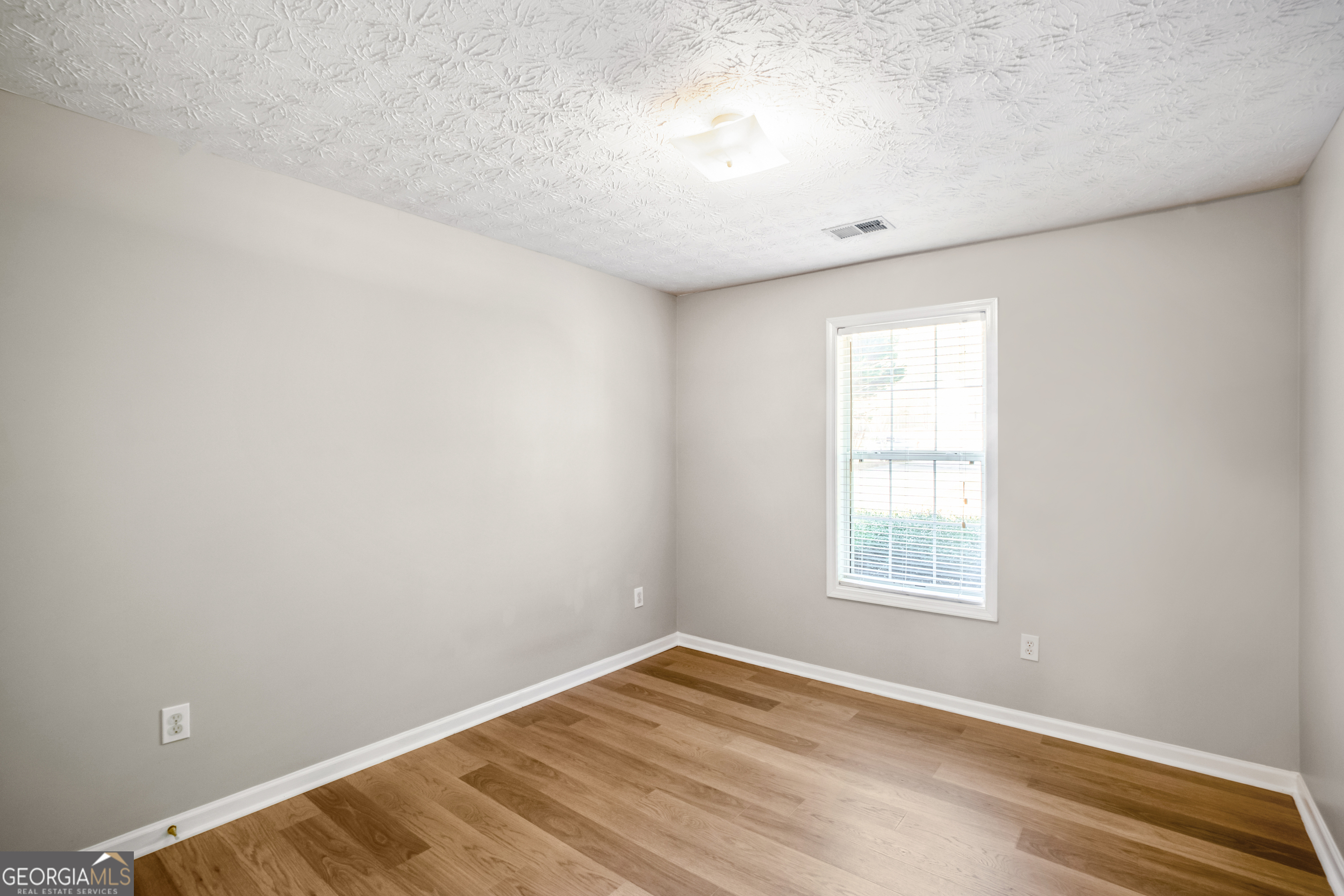 953 Azalea Court Winder, GA 30680 - Photo 16 of 56 an empty room with wooden floor and windows