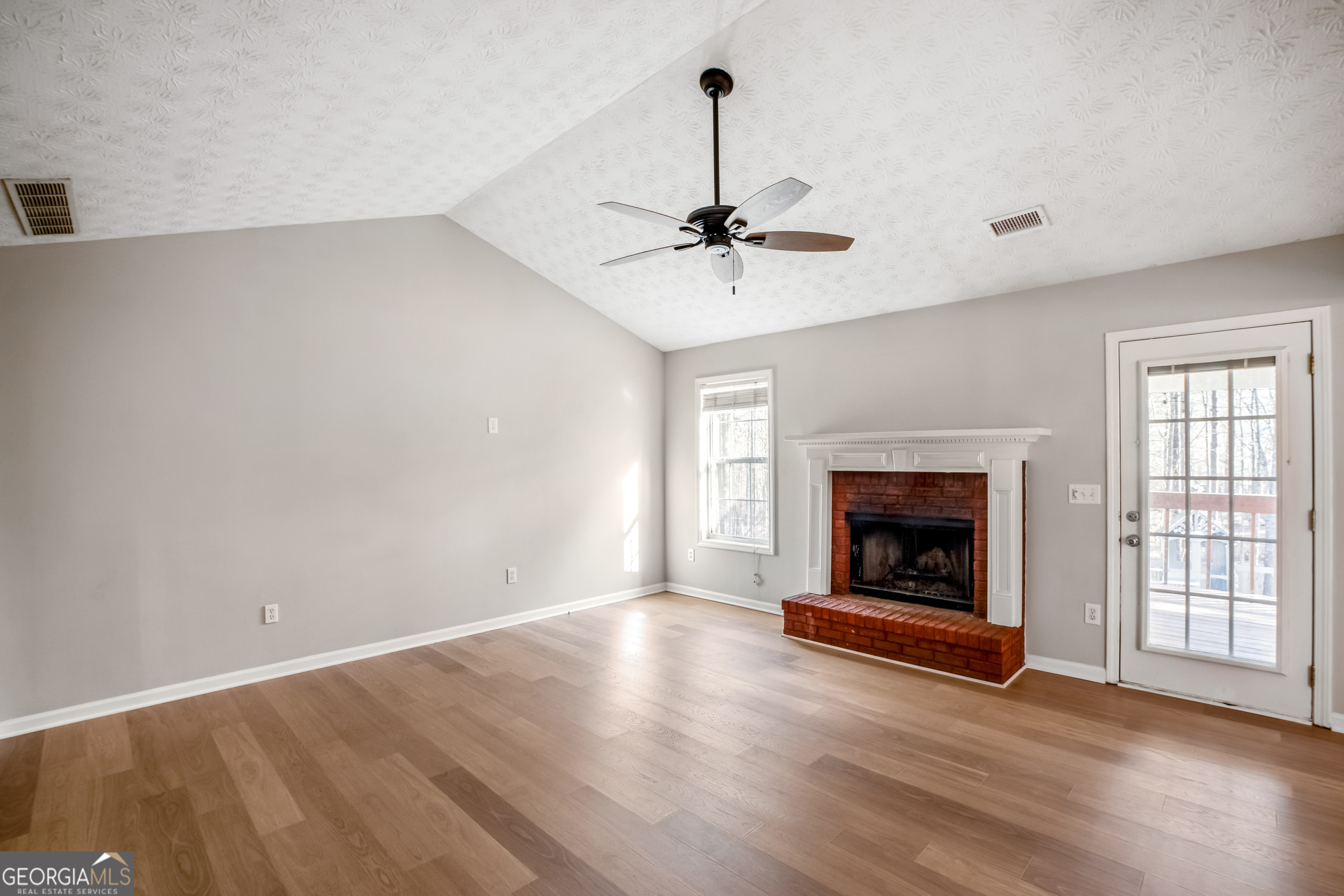 953 Azalea Court Winder, GA 30680 - Photo 6 of 56 a view of an empty room with wooden floor fireplace and a window