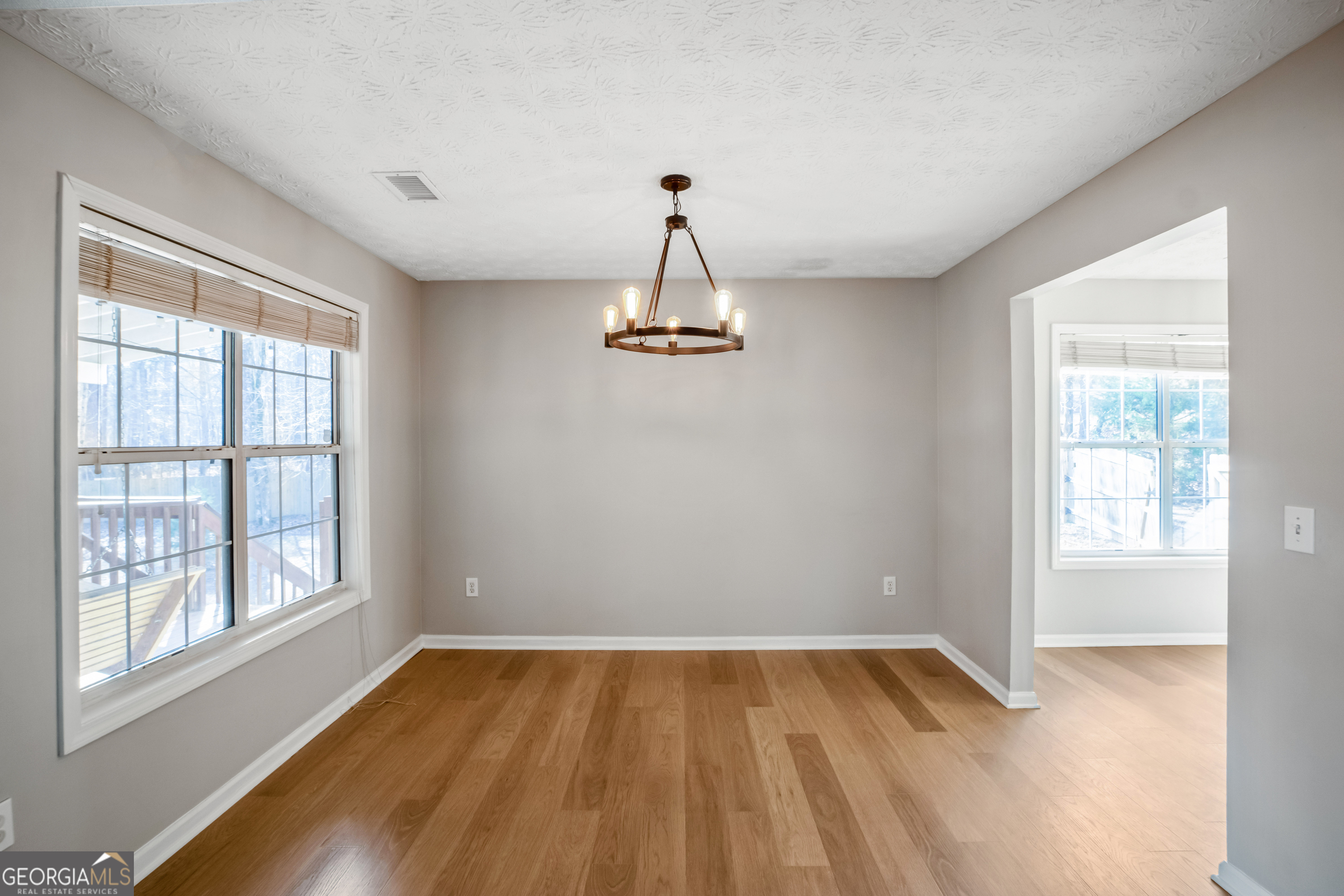 953 Azalea Court Winder, GA 30680 - Photo 7 of 56 an empty room with wooden floor windows and cabinet