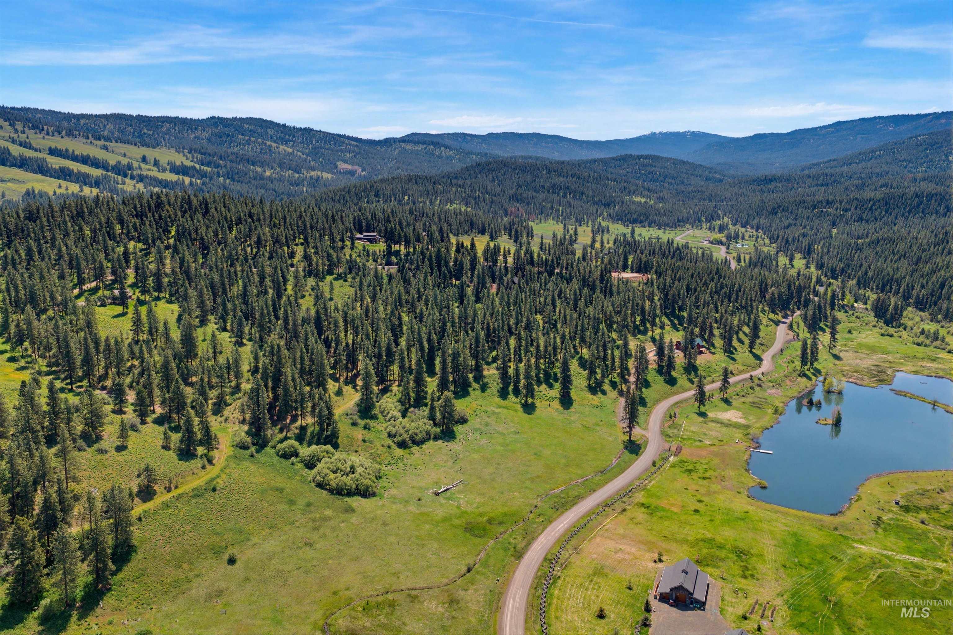 3322 Big Creek Road New Meadows, ID 83654 - Photo 12 of 50 Lush, expansive landscape featuring a large body of water, a winding road, and dense evergreen forests