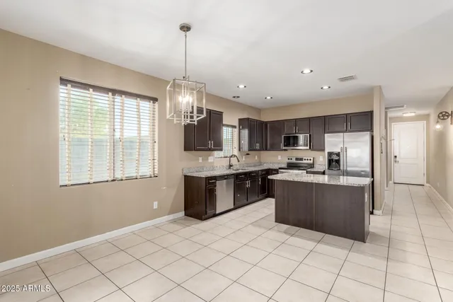 a kitchen with stainless steel appliances granite countertop a sink a stove a refrigerator and a refrigerator