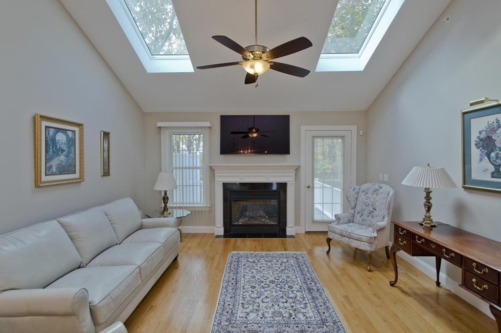 73 Beech Hill Road, Unit 73 West Springfield, MA 01089 - Photo 11 of 29 a living room with furniture a flat screen tv and a fireplace