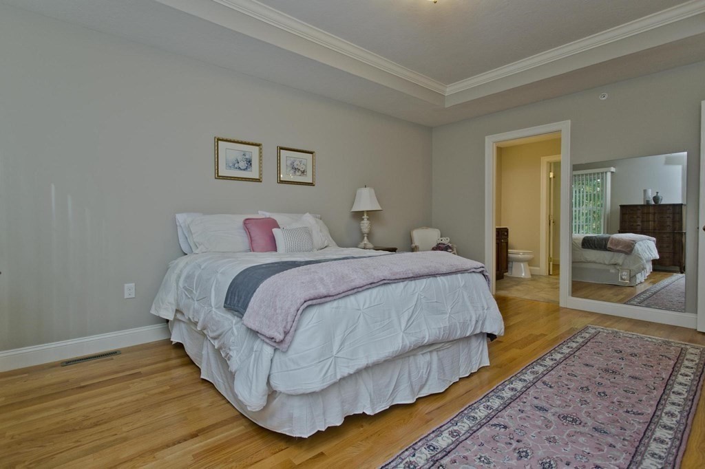 73 Beech Hill Road, Unit 73 West Springfield, MA 01089 - Photo 18 of 29 a bedroom with a bed and wooden floor