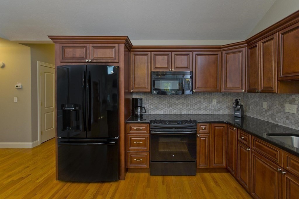 73 Beech Hill Road, Unit 73 West Springfield, MA 01089 - Photo 4 of 29 a kitchen with granite countertop wooden cabinets and stainless steel appliances